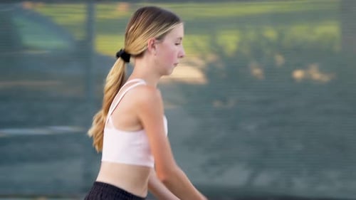 A teenager practicing tennis on a summer afternoon.