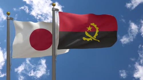 Japan and Angola National Flags Waving Against Blue Sky