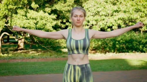 Woman Doing Arm Stretching Exercises in a Park