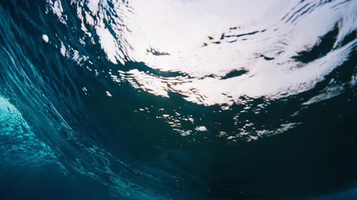 Ocean wave breaks on the shore, underwater view of the wave