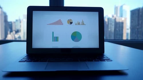 Laptop Displays Charts With Cityscape Background