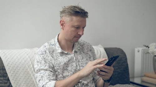 Young Man Reads A Finance News Feed