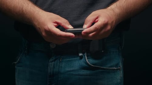 Closeup Macro Hands of a Man Scroll News Feed on Mobile Phone App Application Screen of the Mobile