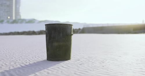Trash Bin Stands Alone on a Deserted Beach During Golden Hour