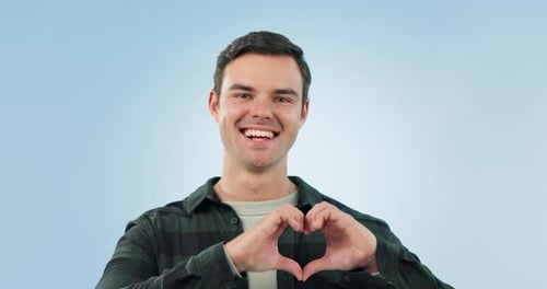 Heart, hands and face of happy man in studio with thank you, motivation