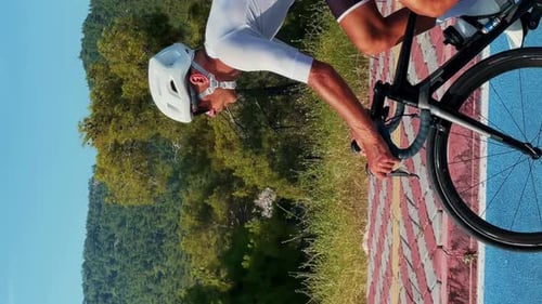 Man riding bicycle along cycle path. Cyclist cycling at summer. Vertical video
