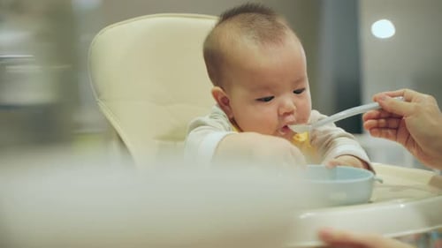 Baby Being Fed in a High Chair