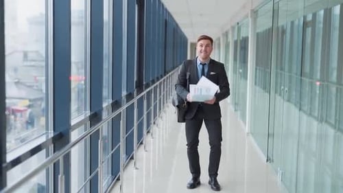 Confident young businessman leaving office tosses papers and goes forward