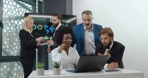 Diverse Team Collaborating on Tech Project in Modern Office