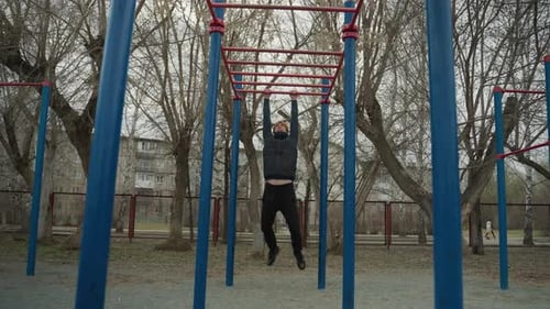 Coach Swinging on Iron Bar in Urban Park with Football Scene in Background