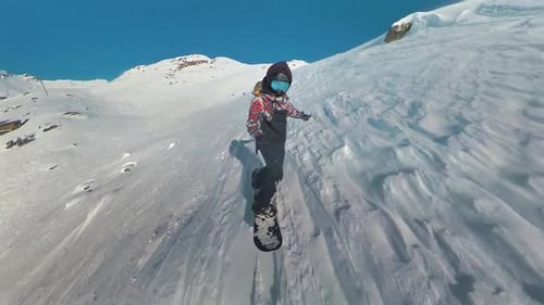 Snowboard freeride. Professional snowboarder ride down the mountain slope at sunny winter day in Fre