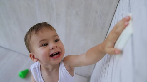 Cute Child Reaches for Light Switch at Home