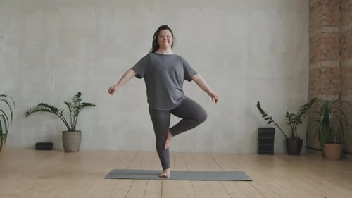 Young Woman With Down Syndrome Standing In Yoga Pose