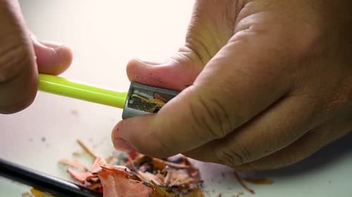 Footage of hands slowly sharpening a pencil and some coloured pencils with a Wedge Pencil Sharpener.