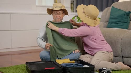 Mature Couple Packing Luggage for Vacation at Home