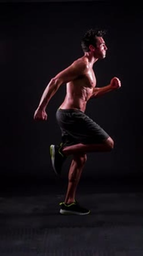 Athletic Man Performing High Knees Exercise Indoors