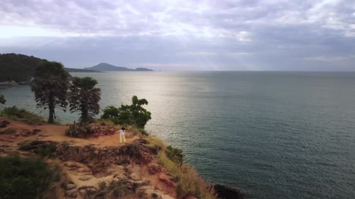 Breathtaking Scenery of Rock at the Coastline and Woman Dancing There Filmed By Drone