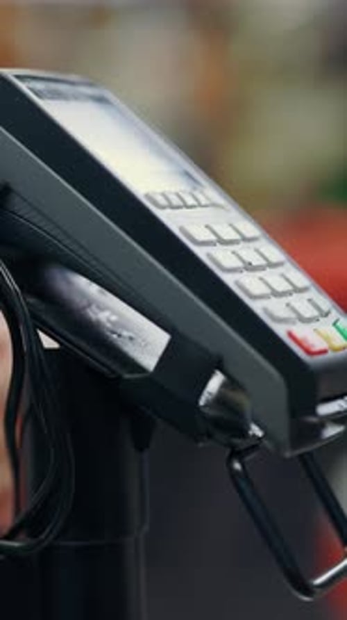 Closeup of Female Customer Hand Putting Phone to Terminal for Contactless NFC Payment in Grocery