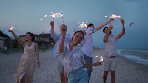 Friends Celebrate with Sparklers on Beach at Dusk