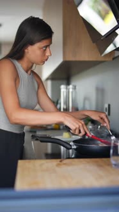 Woman Cooking Meal on Stove in Modern Kitchen
