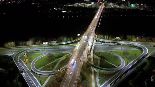 Drone view of the Metropolis Building at night and a street with heavy traffic. Crossroad Night capi