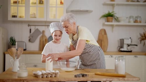 Child and Senior Woman Cooking Together Indoors