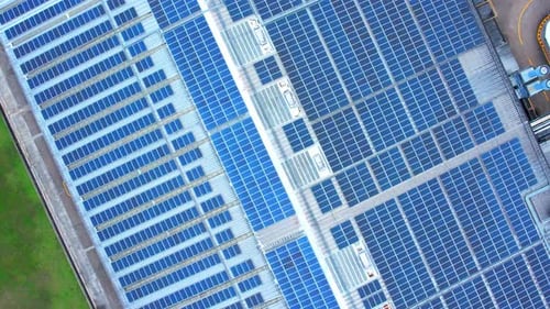 Aerial view of the blue solar panels on the roof of a factory