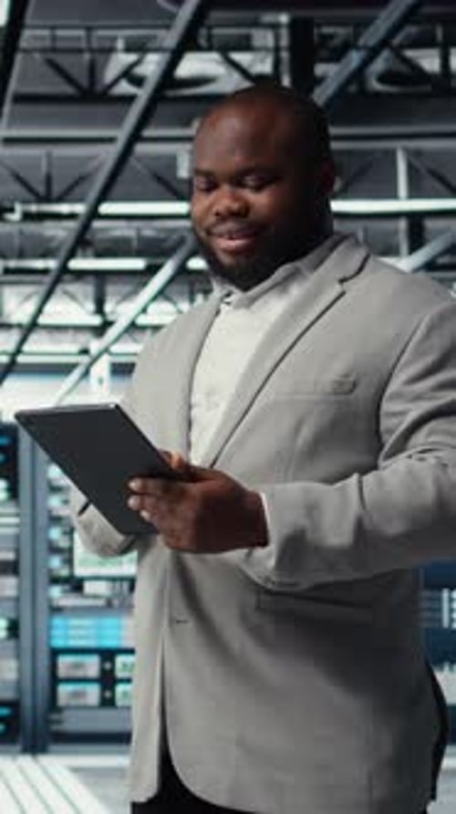 Vertical Video Cheerful Data Center Programmer Looking at Code Debugging Tools on Tablet