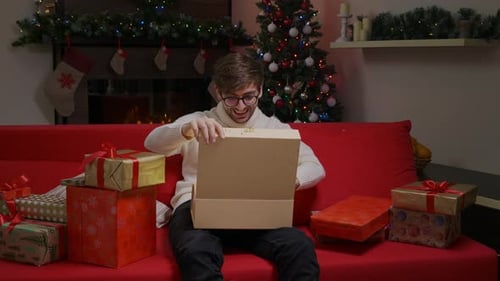 Man Excitedly Opens Christmas Gift at Home