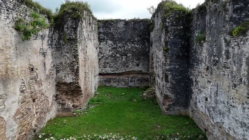 Moving Backward Through Historic Stone Walls and Grass-Covered Ground