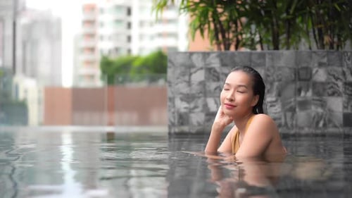 Fashion asian model swimsuit posing in a pool