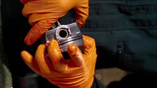 Vertical Video Closeup At a Service Station on the Table Young Engine Repairman Assembles a New