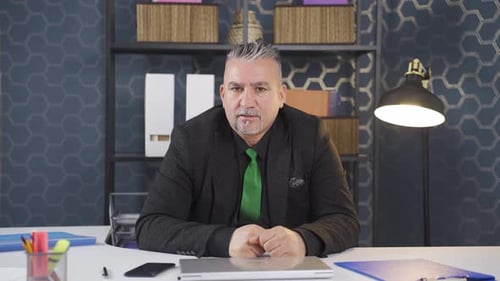 Mature Adult Man Video Conferencing at His Desk