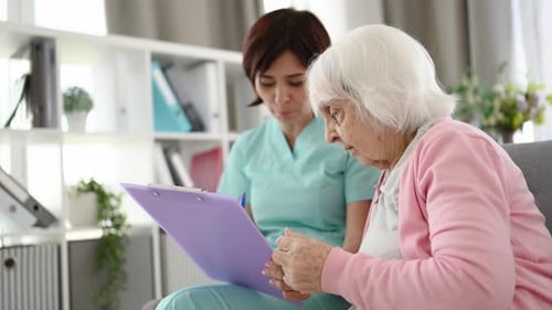 Medical Worker and Senior Woman Reviewing Documents