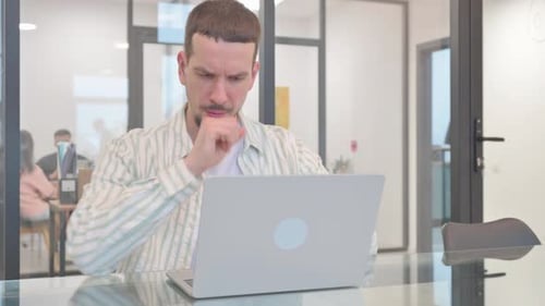 Young Adult Coughs While Working On Laptop