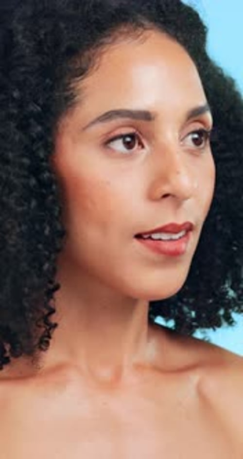Visage, brillance et femme en studio, soins de la peau et dermatologie sur fond bleu