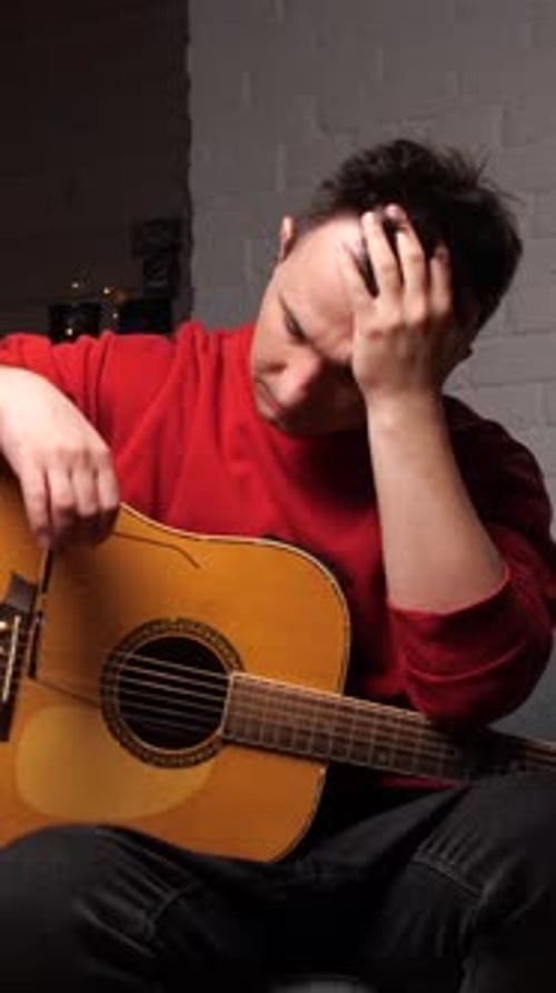 Vertical Video Upset Man with a Guitar Grabbed His Head with His Hands