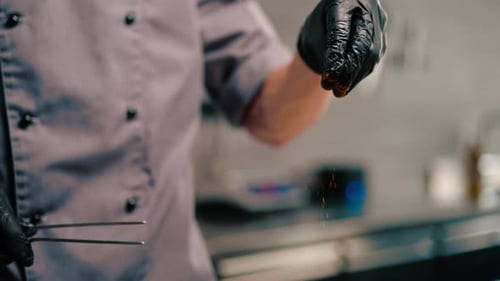 close-up of a chef in a professional kitchen preparing seafood saute mixing ingredients in a pan