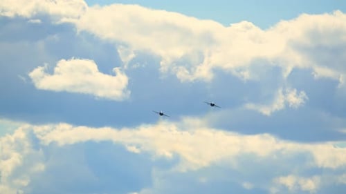 Two fighter jets flying high in a cloudy sky