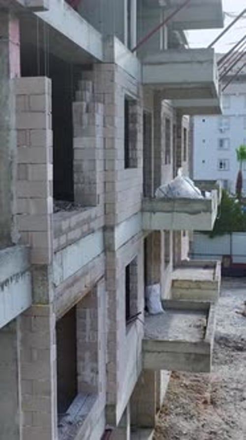 Vertical Video Workers Performing Multiple Construction Tasks With Machinery in the Background