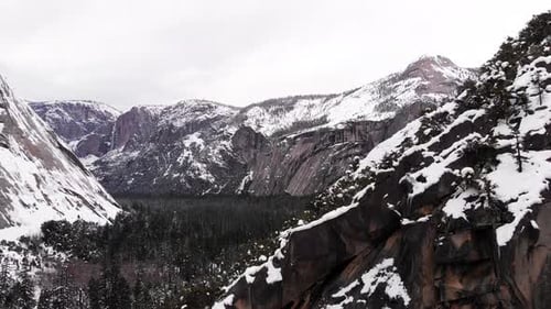 Aerial Drone footage, flyover cliff and drop-off over Yosemite valley revealing mountain range blank