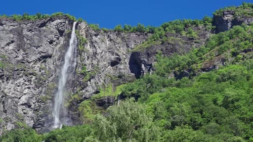 A beautiful view of the waterfall in Geiranger fjord, Norway. A powerful stream of water falling fro