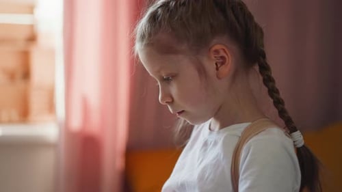 Pensive Child with Braids Indoors