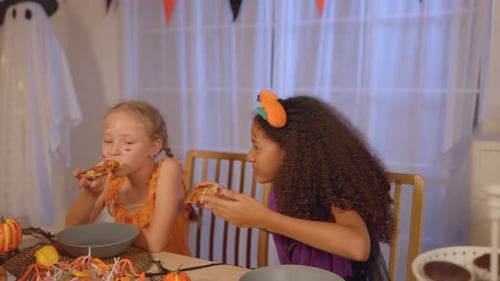 Girls and Man Eating Pizza at Halloween Party