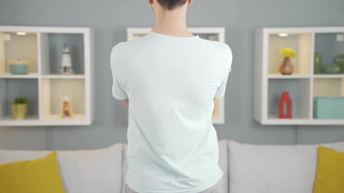 Young Adult Male Stretching Arms Indoors