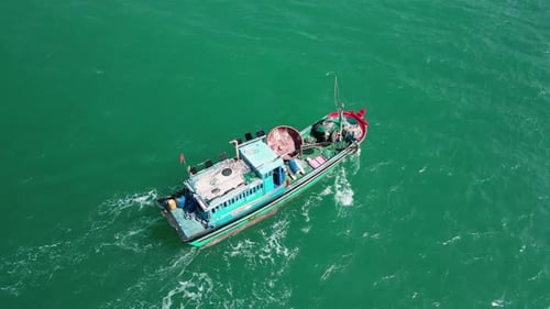 Fishing Boat Sailing on Green Sea Water