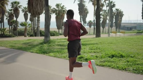 African American Man Running in a City Park Near the Beach Training Morning Workout