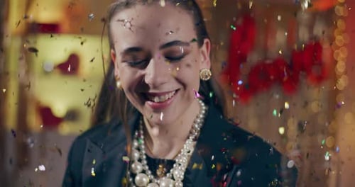 Woman Smiles as Confetti Falls at a Party