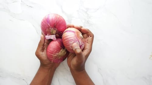 Top View of Men Holding Red Onions