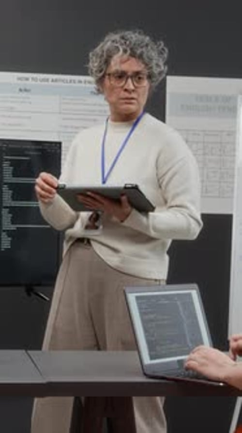 Woman Discussing Code with Colleague in Workplace Setting
